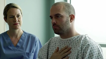 bald cauasian man puts his hand on neck with serious expression on his face, nurse nearby. thyroid cancer awareness month. remission, healthcare and medicine. hospital patient, treatment, chemotherapy