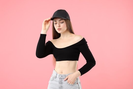 Fototapeta Portrait of beautiful woman in stylish baseball hat on pink background