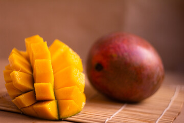 Close-Up of a Sliced Mango and a Whole Fruit on Bamboo Mat