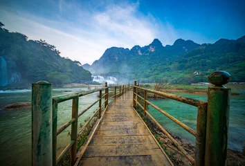 Gordijnen Bos rivier Bridge to Ban Gioc Waterfalls, a famous cross-border waterfall between Vietnam and China  © lkunl