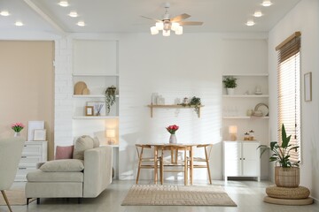 Stylish dining table with chairs and comfortable sofa in room. Interior design