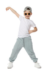 Happy little boy in sunglasses and baseball hat dancing on white background