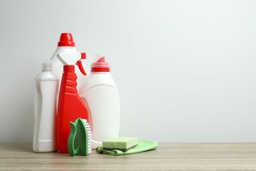 Assorted cleaning tools including brush, sponge, spray bottle, and detergent on tne table....