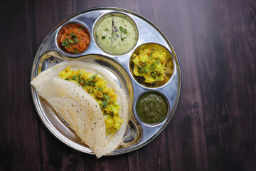 Crispy Masala dosa is a popular South Indian food item served with tomato chutney, coconut chutney, spicy potato masala, or aloo ki sabzi and sambar. Copy space. Crunchy Rice crepes.