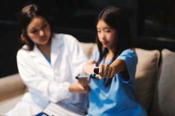 Doctor physiotherapist assisting a male patient while giving exercising treatment on stretching his...