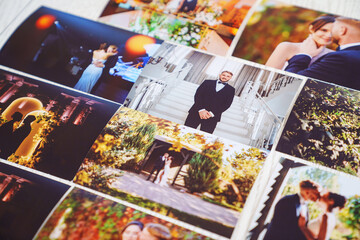 Printed wedding photos laid out on a wooden surface.