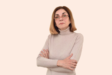 Portrait of confident, serious and strict middle-aged woman with crossed arms and eyeglasses. Copy space. 