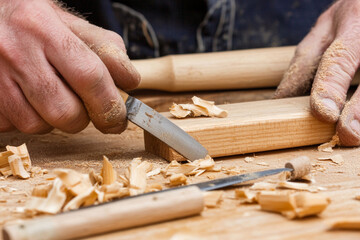 Carpenter crafting furniture in workshop using hand tools