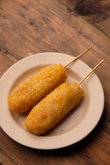 A corn dog is a hot dog on a stick that has been coated in a thick layer of cornmeal batter and deep fried