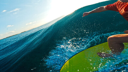 Person in red shirt surfs the wave in the tropics
