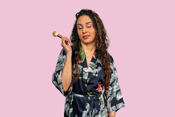 Beautician applying makeup with brush: pink background