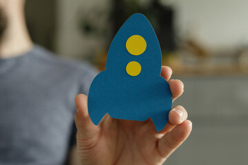 Image of a hand holding a paper rocket, symbolizing new beginnings and innovation.