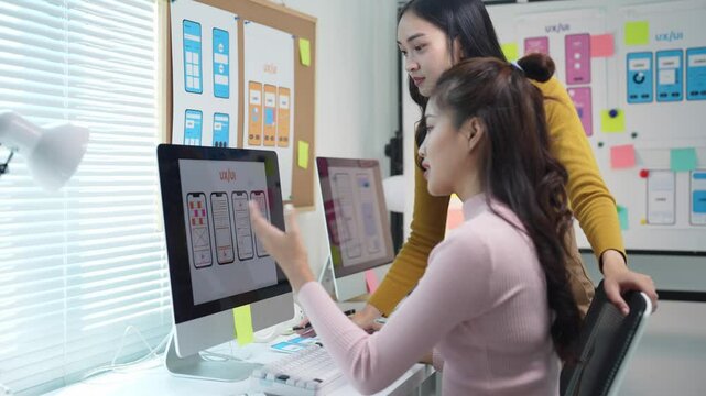 Web designers discussing user interface on computer