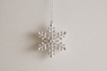 beautiful christmas ornament shaped like snowflake elegantly designed and placed on clean neutral background