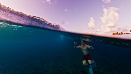 Man swims in the sea with breaking waves. Splitted shot of the male swimming in the ocean on a surfing spot