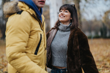 Joyful people engaging outdoors in an autumn park, wearing cozy fall clothing, radiating happiness...