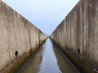 A narrow concrete irrigation canal