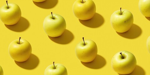 Pattern of fresh yellow apples on bright yellow background