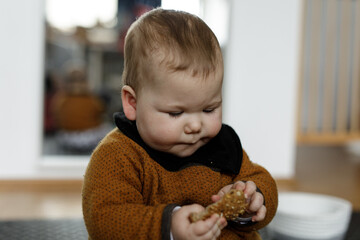 Cute baby happily enjoying a nutritious snack. Perfect for blogs, parenting websites, and food...