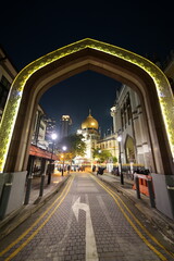 The Sultan Mosque in Singapore glows majestically at night, its golden dome and illuminated...