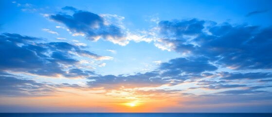 Obraz premium Stunning Sunset over Ocean Horizon with Blue Sky and Clouds