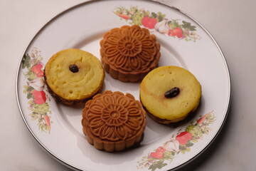 Sweet dessert, kue Lumpur and mooncakes in floral plate. Asian food.