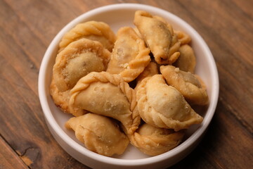 mini pastel filled with shredded meat in white plate. savory snack. Pastel abon. 