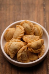 mini pastel filled with shredded meat in white plate. savory snack. Pastel abon. 