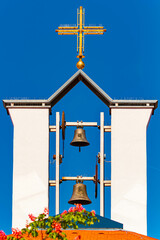 Details of a clock tower with a cross on a sunny day near Bad Griesbach im Rottal, Passau, Bavaria,...