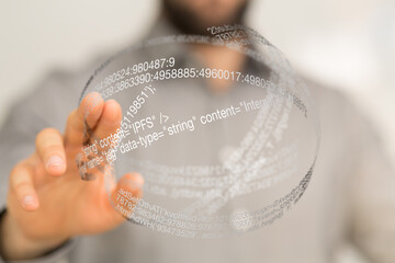 Close-up of a hand interacting with a transparent sphere displaying code.