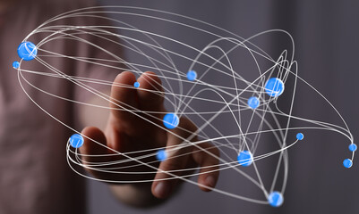 Abstract image of a hand interacting with a complex network of interconnected nodes, representing global communication and digital connectivity.