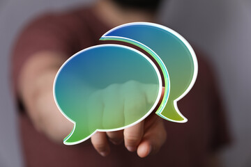 Abstract image of a person interacting with digital speech bubbles, representing communication and...