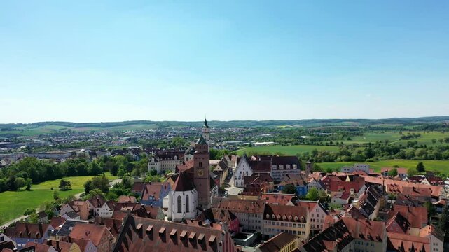Luftaufnahme von Donauw&ouml;rth mit roten D&auml;chern, historischen Geb&auml;uden und einem markanten Turm, eingebettet in eine gr&uuml;ne Landschaft. Die Stadt bietet eine charmante Kulisse. 
