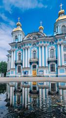 Panoramic view of St. Nicholas Naval Cathedral with beautiful reflection in water. Nikolo-Bogoyavlenskiy Morskoy Sobor built in 1762 in Saint Petersburg, Russia