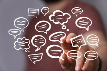 Image depicts a hand interacting with various speech bubbles, symbolizing communication, dialogue,...