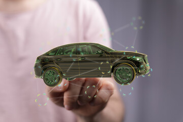 Person holding a digital 3D model of a car, showcasing automotive technology and innovation.