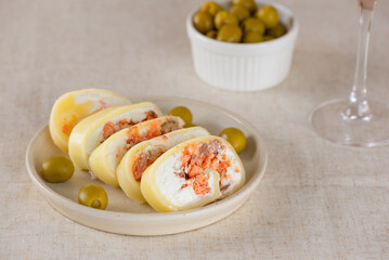 Farm cheese roll with salmon, olives and cream cheese with white non-alcoholic wine. Healthy rustic breakfast.