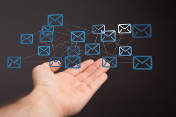 Hand holding interconnected email icons, representing global communication and networking.