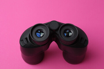 Black binoculars on background. Flat lay, top view