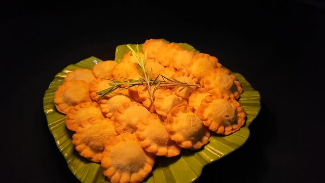 Pasteles dorados sobre plato verde.