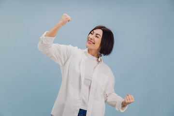 Excited mature businesswoman celebrating success on blue background