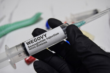 Wegovy semaglutide injection novo nordisk drug syringe in black gloved hands. Medical concept