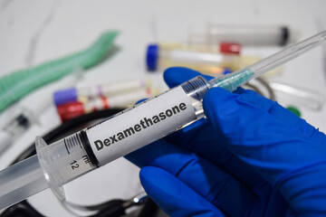 Dexamethasone drug syringe in blue gloved hands. Medical concept
