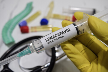 Lenacapavir vaccination drug syringe in yellow gloved hands. Medical concept