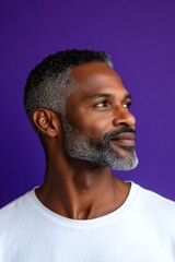 Fototapeta premium A stylish and confident man with a poised stance. A graceful mature man with a modern hairstyle. A joyful male captured in a professional portrait. A happy man in a studio photo.