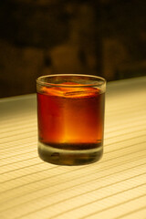 Negroni campari cocktail with translucent ice on illuminated bar in pub