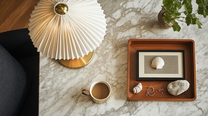 Elevated view of a marble table, featuring a lamp, tray, framed artwork, and coffee