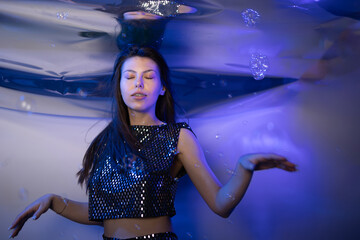 Fototapeta premium Girl Dressed as a Mermaid Floating Effortlessly in a Magical Underwater Setting