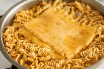 Adding cheddar cheese on pan-fried noodle ramen