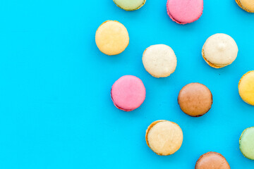 Macarons dessert pattern on blue background top view copy space